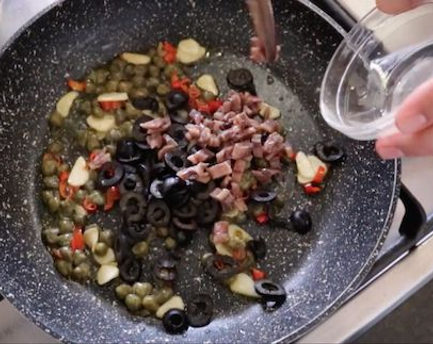 step 8 Then add the slices of black olives and chopped anchovies and mix everything together, then add Canned Diced Tomatoes (1 3/4 cups), season with Salt (1 pinch), Ground Black Pepper (1 pinch), Granulated Sugar (1 pinch) and Dried Parsley (1/2 tsp). Mix everything until its well combined and lower the fire to a low heat.