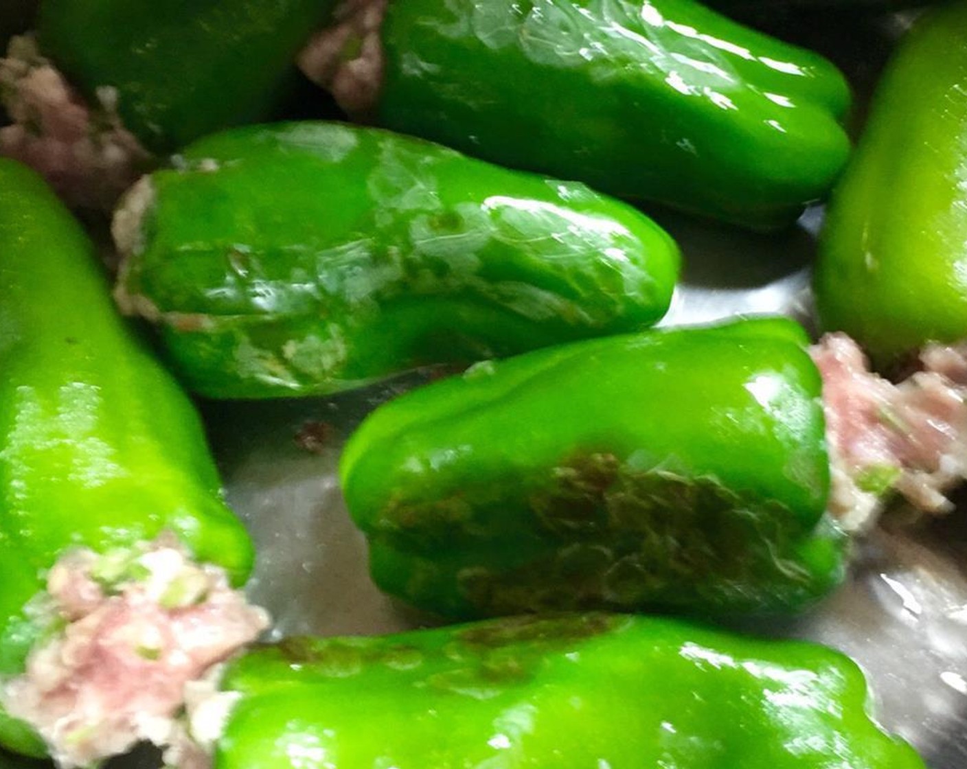 step 6 Add the Vegetable Oil (2 Tbsp) into the pressure cooker and put on low heat. Line the stuffed green peppers along the bottom and fry sloghtly, turning them constantly for one minute.