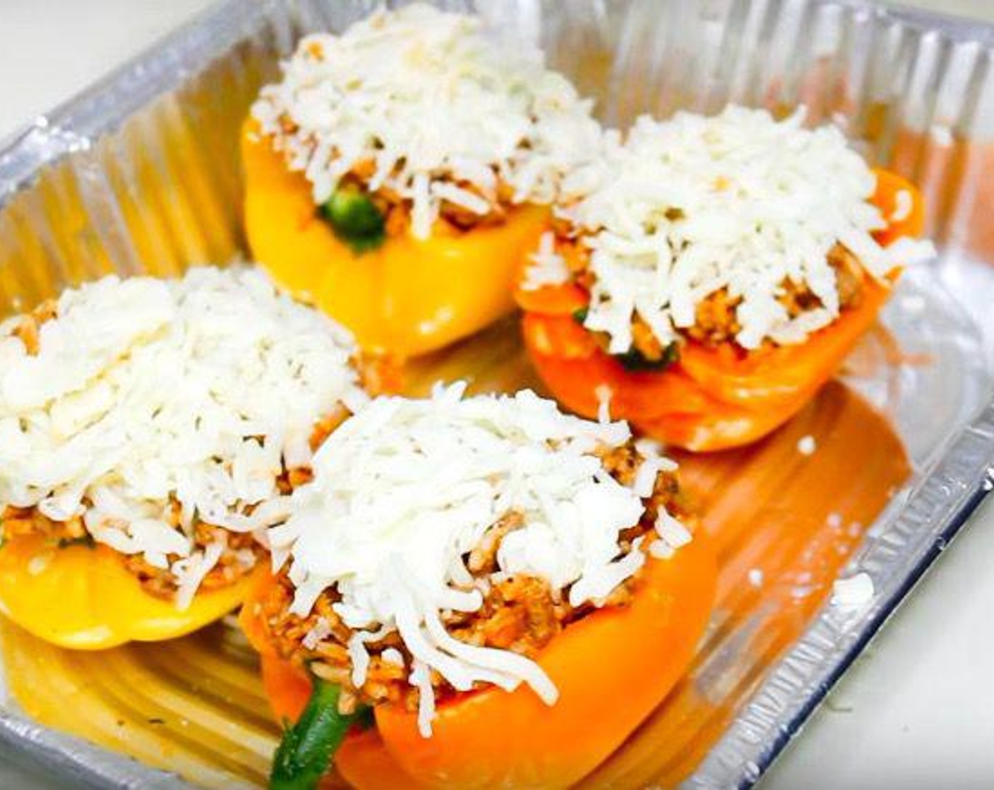 step 6 Spoon rice filling into each pepper and top with Mozzarella Cheese (to taste). Place finished peppers in an oven-safe dish.