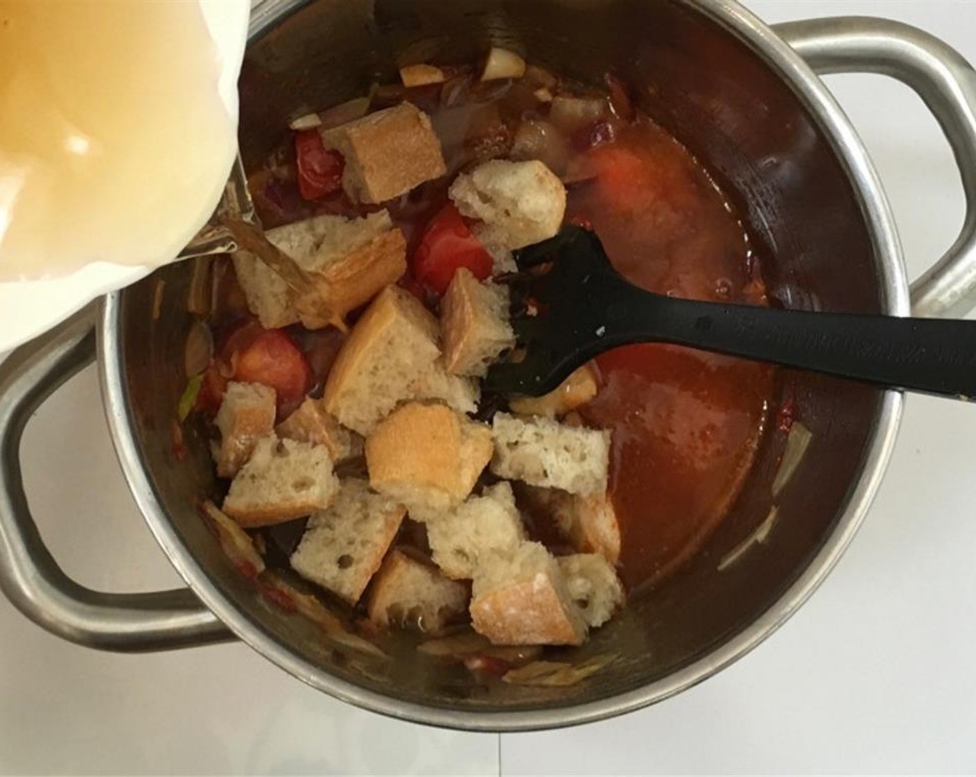 step 3 Stir again. Dice the White Bread (1 slice) up roughly and add it to the pan together with the Vegetable Stock (1 1/2 cups). Season with Ground Black Pepper (to taste).