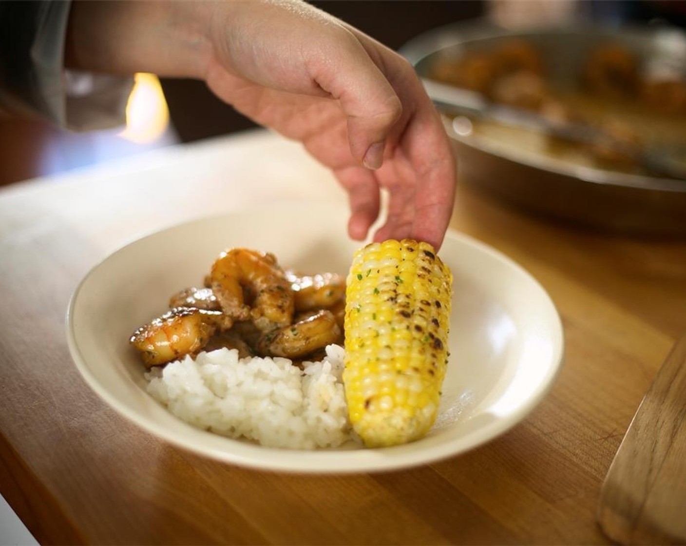 step 22 Plate corn on the opposite side of the shrimp. Garnish with parsley sprigs in the center of each plate and baguette on the side.