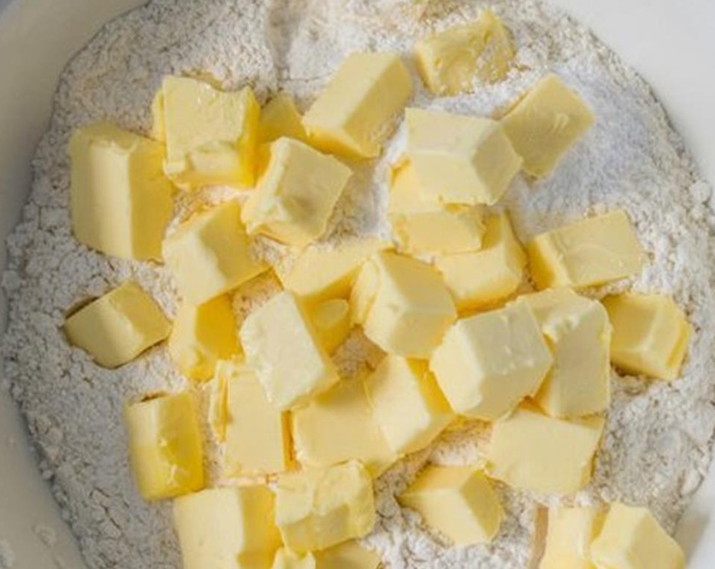 step 4 Cut the Butter (2 1/2 sticks) into cubes and toss into flour. Use your hands to combine the butter and flour until the flour is crumbly. Add in the whole Eggs (2) and Water (1/4 cup).