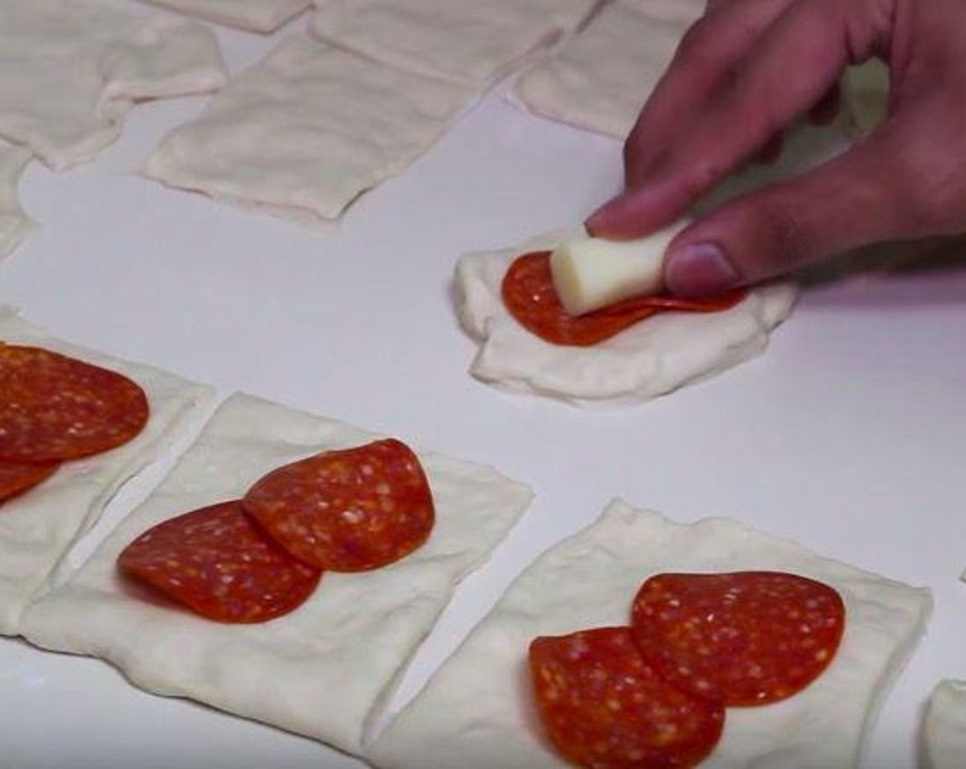 step 1 Put the Pizza Dough (1 lb) on a floured surface. Form it into a rectangle and evenly cut the dough into 24 pieces. Put 2 pieces Pepperoni Slices (to taste) and one piece of Mozzarella Cheese (to taste) for each dough.