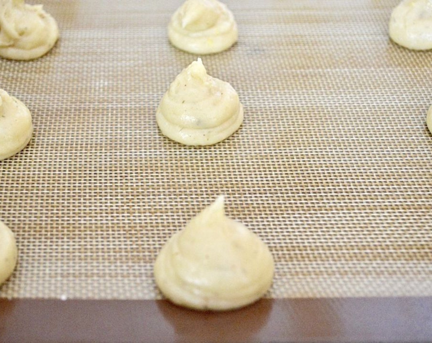 step 5 Transfer the dough to a piping bag and pipe little mounds of the dough right onto the baking sheet. You should get about 12 perfect little puffs. Sprinkle a little water on the sheet around the puffs.
