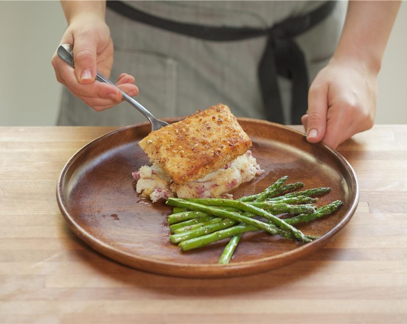 step 14 In the center of two plates, place the mashed potatoes. Add the halibut fillets directly on top. Plate asparagus next to mashed potatoes. Spoon sauce over the fish.