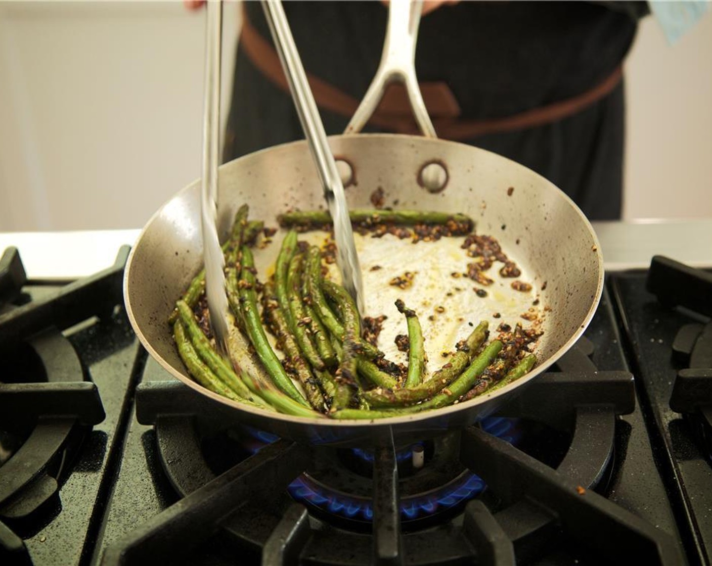 step 11 Heat medium saute pan over high heat. Add Oil (1 Tbsp). Once the oil is hot, add green beans, being careful as beans may splatter.