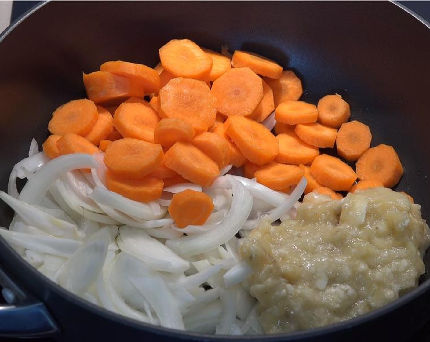 step 1 Pour the Vegetable Oil (as needed) into a pan over low heat. Add in Yellow Onions (2), Carrots (3), and Banana (1). Cook the mix for five minutes while stirring it occasionally, until the onions start to go translucent and the carrots soften.