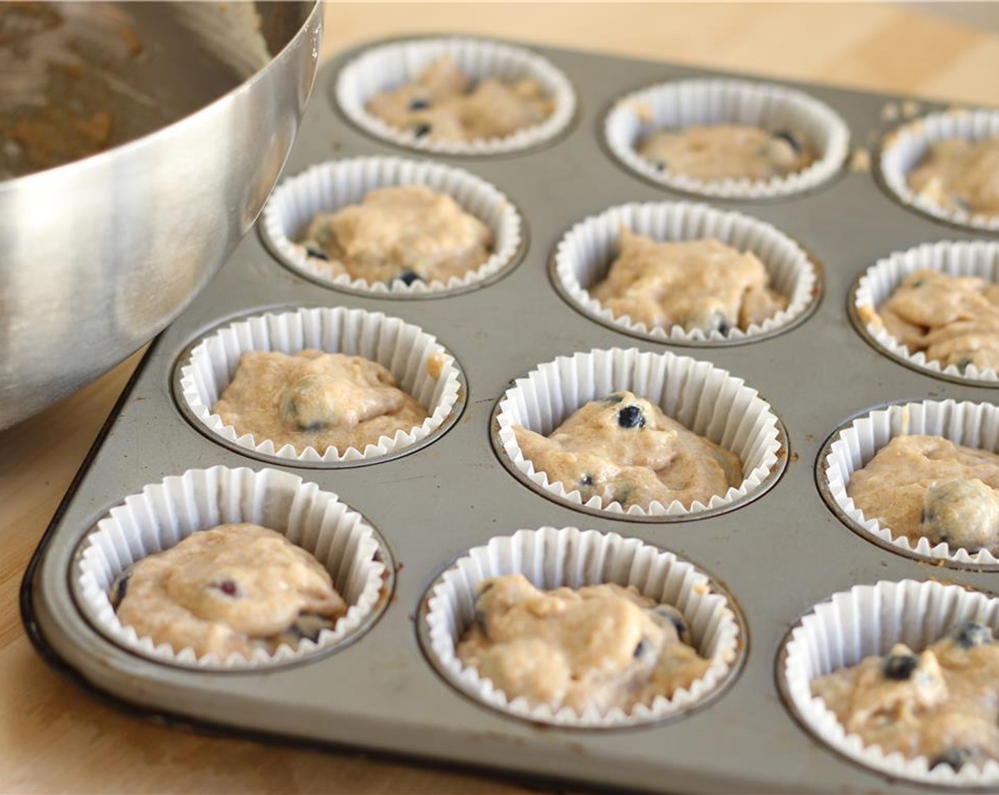 step 10 Evenly distribute the batter by spooning it into the muffin tins.