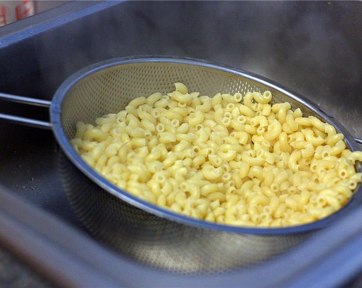 step 7 When the pasta is cooked to al dente, drain into a colander but do not rinse. The starch from the cooking water will help the cheese sauce to stick to the noodles. Return noodles to the pot and cover until the cheese sauce is ready.