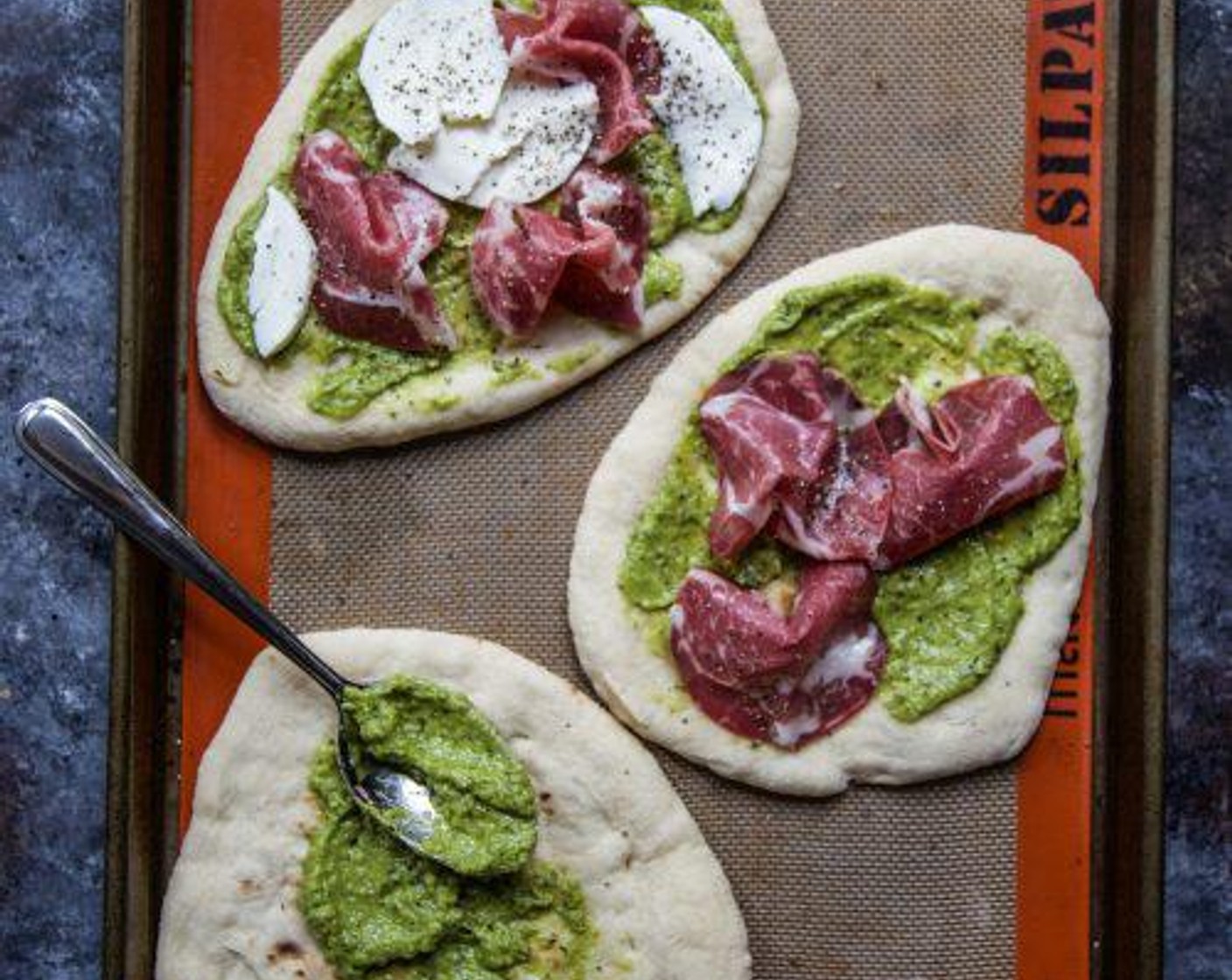 step 4 Next, spread the avocado pesto on each Whole Wheat Flatbread (4 pieces) leaving a 1/2 inch border. Top the avocado pesto with some Soppressate (12 pieces) and Mozzarella Cheese (12 slices).