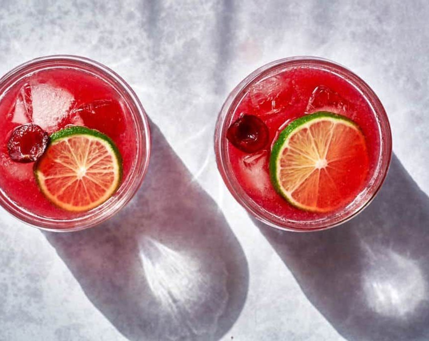 step 5 Put ice in your 2 cocktail glasses. Pour the gin mixture over the ice, drop in 1-2 tablespoons of the macerated cherry chunks, and add a slice of lime to serve.