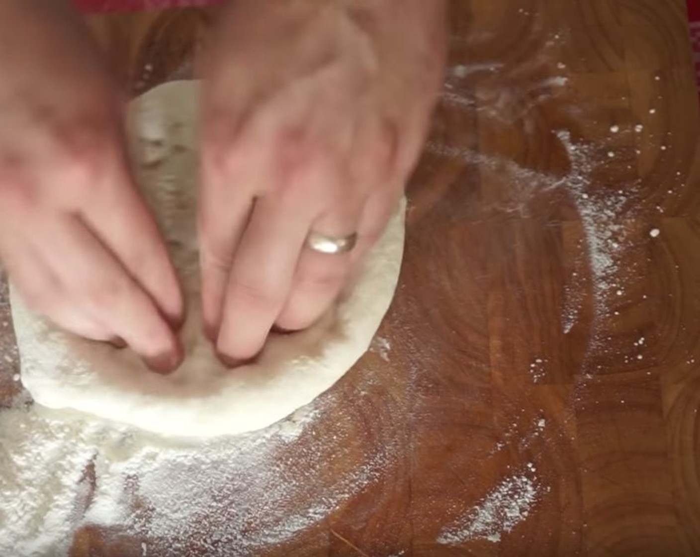 step 11 Get one of your pizza balls, place it on a surface dusted with flour, and coat both sides of the dough with the flour. To stretch out the pizza, starting from the middle, poke down using both hands, and work it in a circular motion, leaving a gap for your crust. Turn it over, and stretch it just a little bit, or try your hand at a little spin and stretch in the air if you dare!