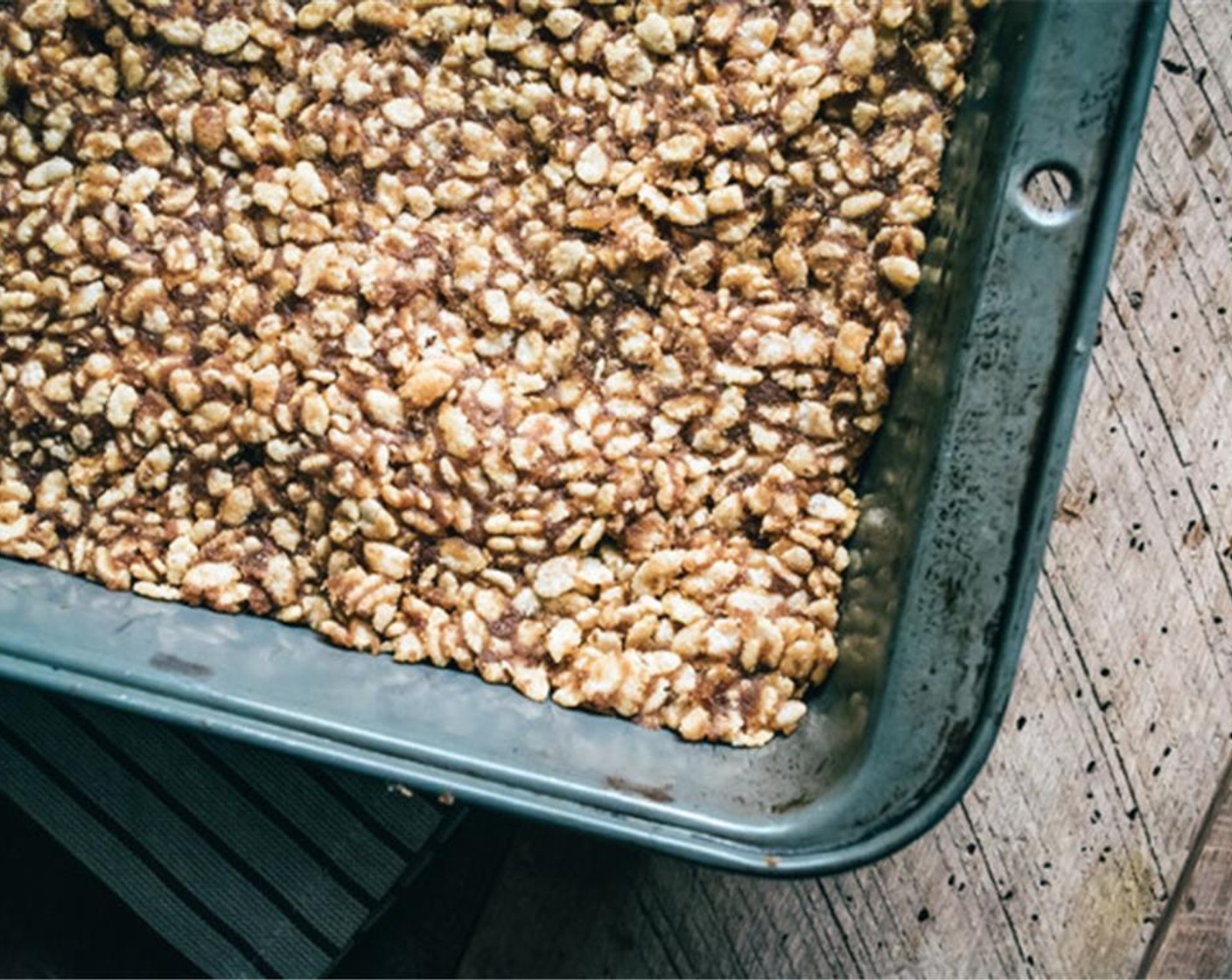 step 5 Grease a 9x13-inch baking dish with Nonstick Cooking Spray (as needed), then add the toasted rice cereal mixture to dish, smooth into even flat layer, using spatula to press mixture down firmly.