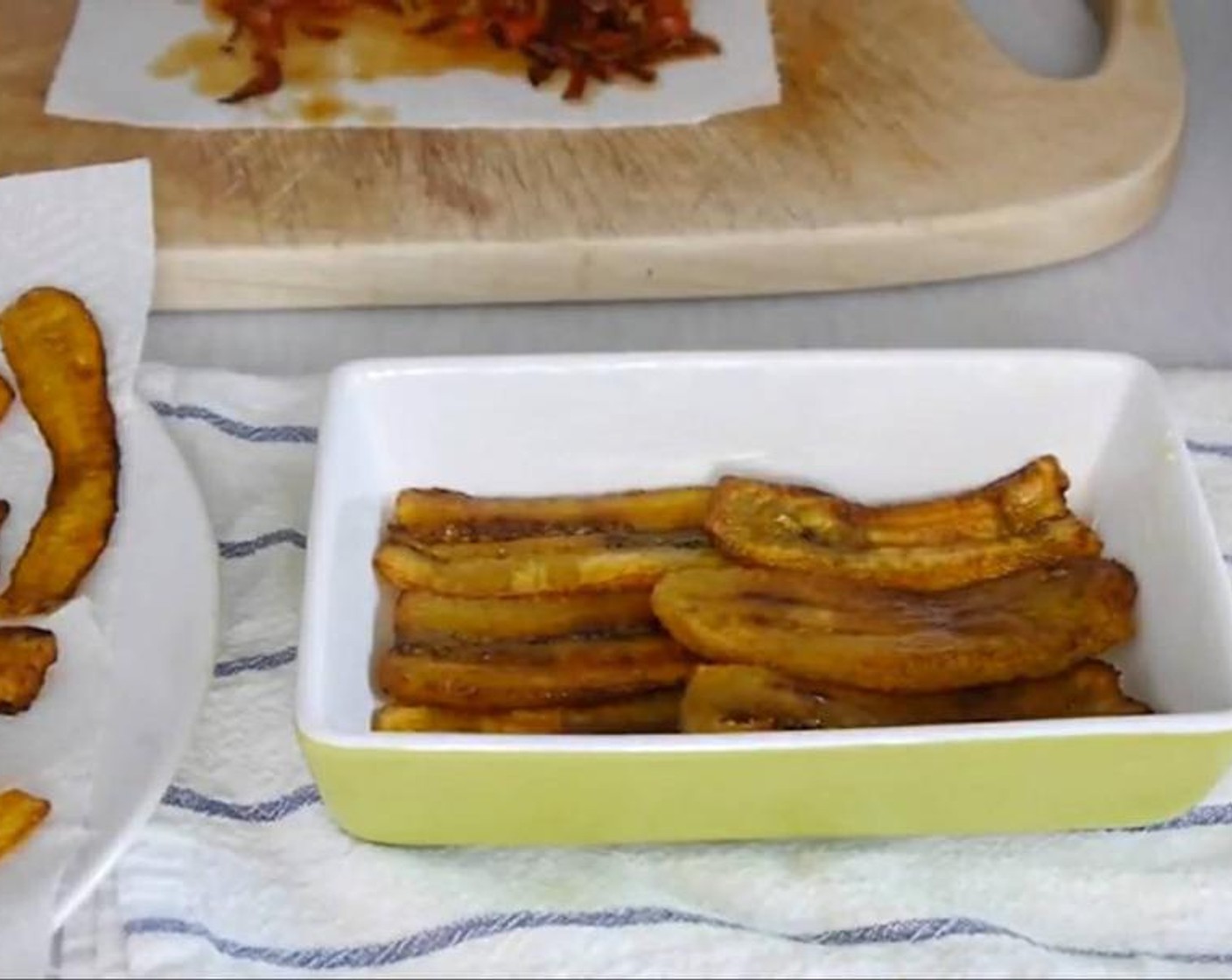 step 3 With your fingers butter a baking tray to avoid sticking and start to form the layers placing one layer of fried Plantains (3) then a layer of chorizo and a layer of the Feta Cheese (2/3 cup). Add a tsp of Muscovado Sugar (1 Tbsp) in between each layer,  this with the melted cheese will make a cheesy sweet syrup.