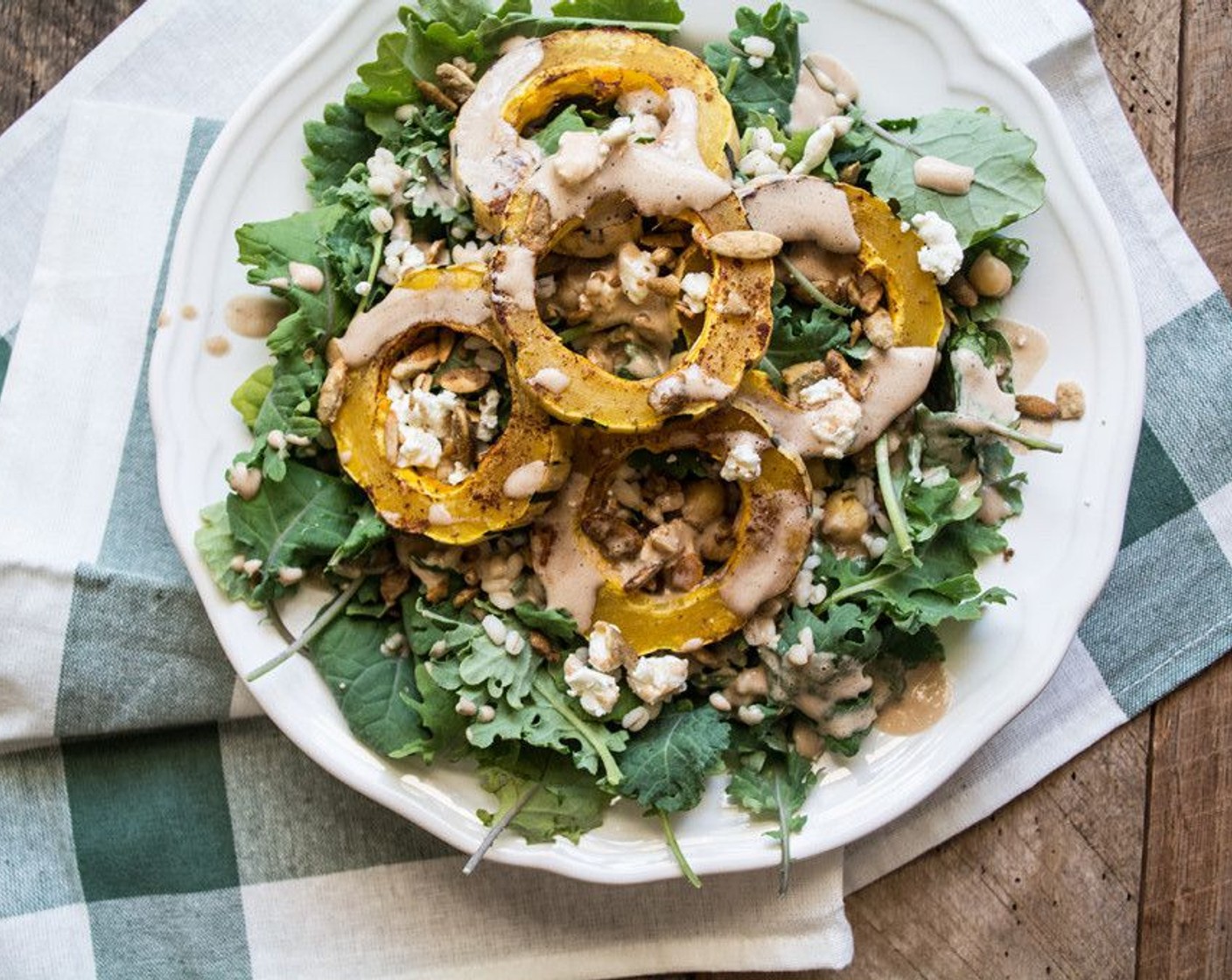 step 8 Then layer each salad with cooked delicate squash, Goat Cheese (2 Tbsp) and Pepitas (1/4 cup). Drizzle with Pumpkin Almond Balsamic Vinegar Dressing or dressing of choice.