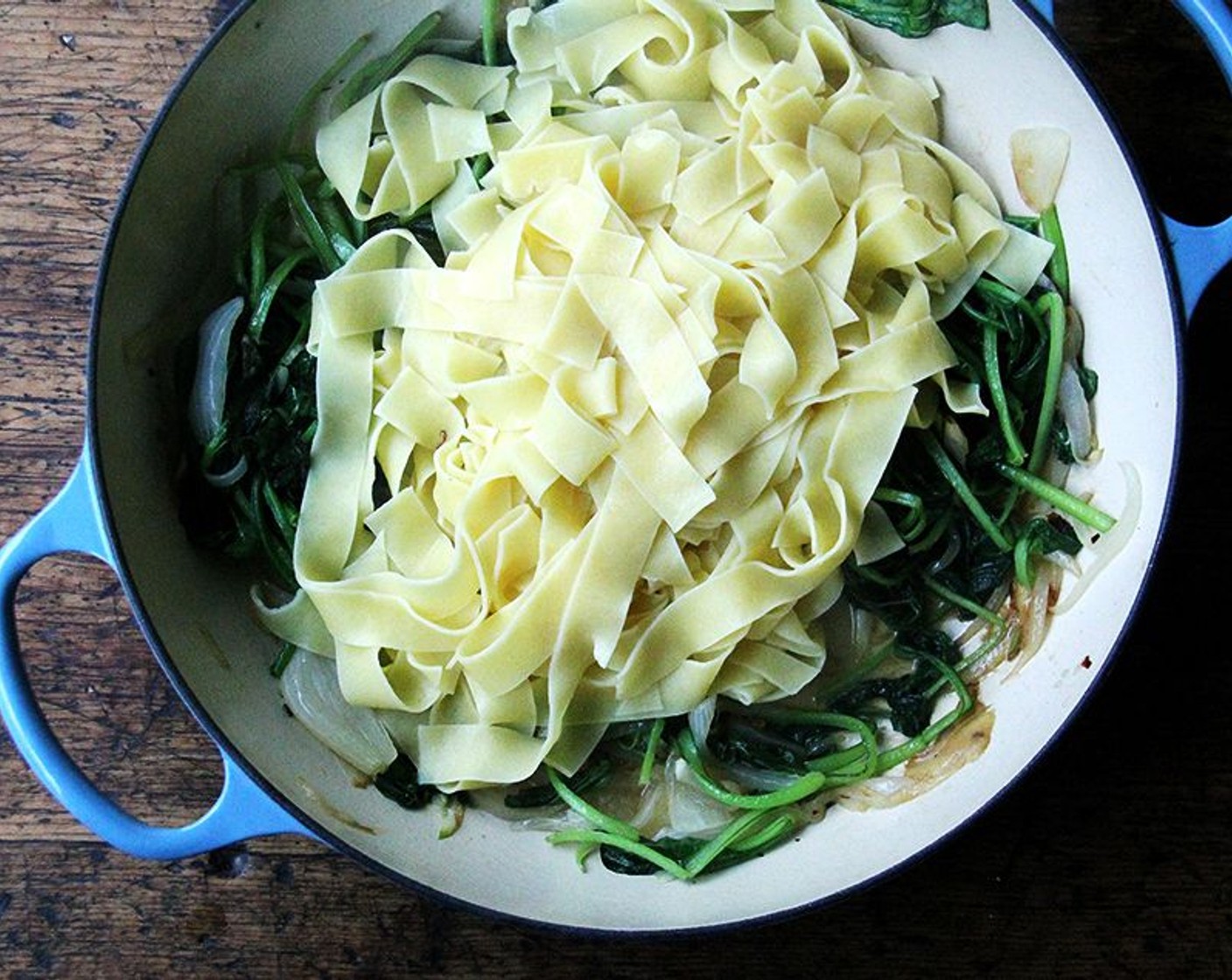 step 7 Drain pasta and immediately add to the pan with the onions and greens.