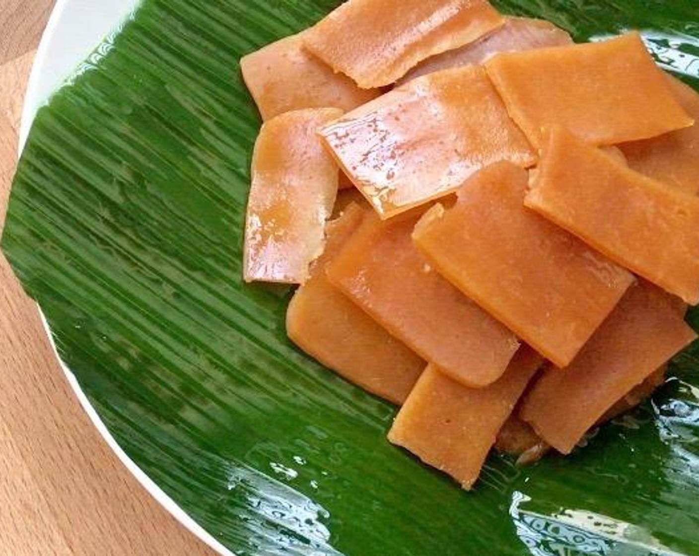 step 3 Place the nian gao slices on a large, heat-proof plate lined with oiled Banana Leaves (1).