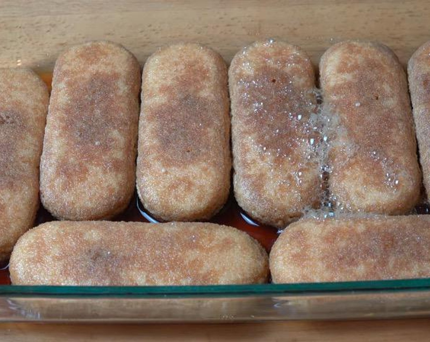 step 2 Arrange Ladyfingers (8) in a glass baking dish and pour the remaining coffee mixture over the top. Set aside for 15 minutes to allow the liquid to absorb.