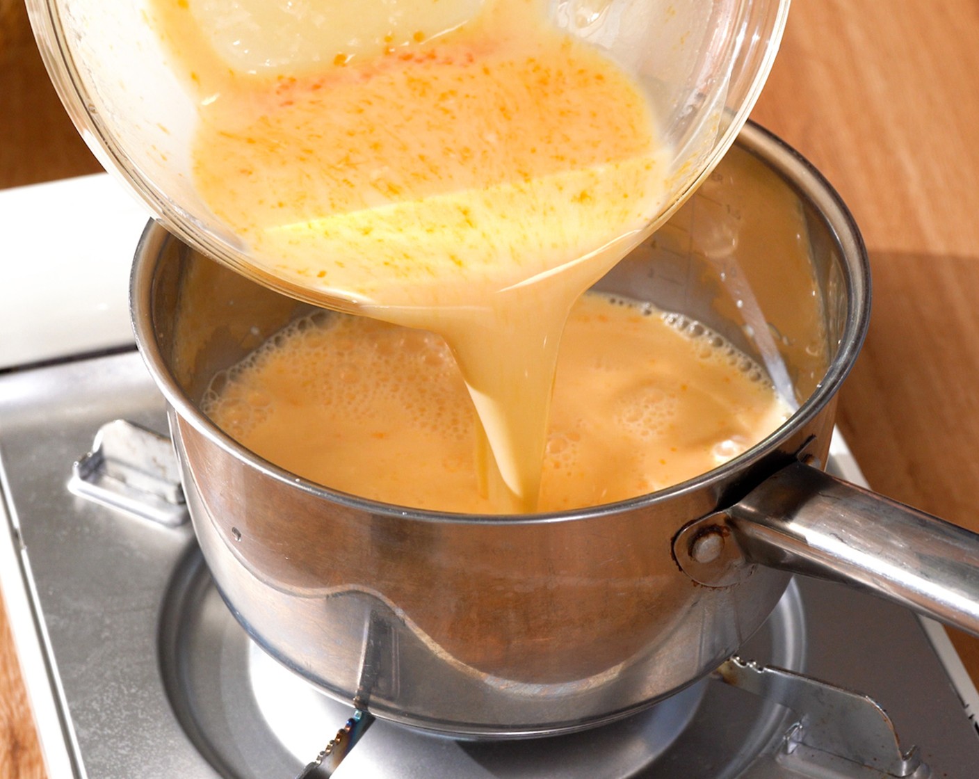 step 5 Pour the mixture into a saucepan, whisking constantly. Over medium heat, continue whisking the mixture until thickened.