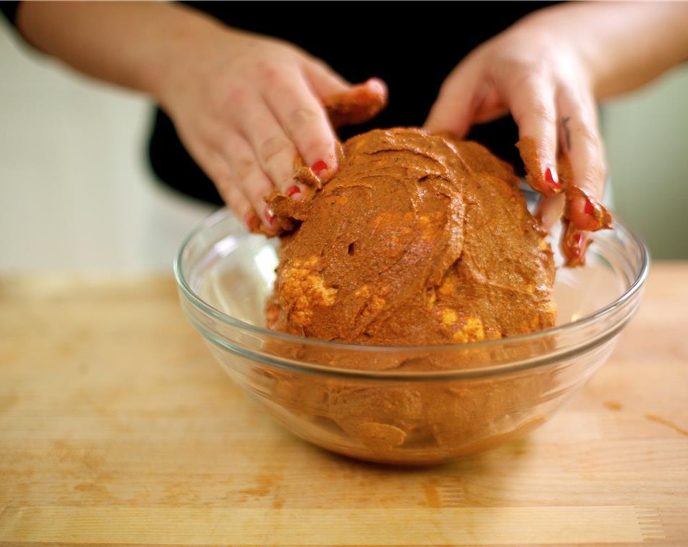 step 4 Dunk the whole head of cauliflower into the bowl and use a pastry brush or your hands to spread the marinade evenly over the surface.