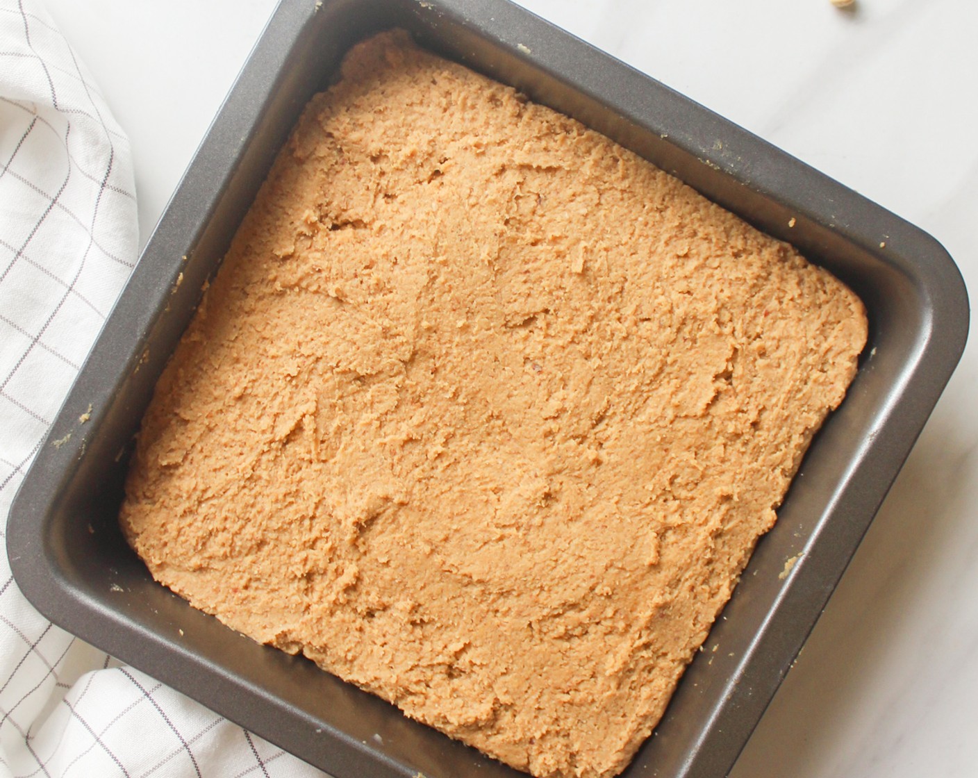step 5 Transfer the batter into a greased 8x8-inch baking pan. Smooth it out using a spatula.