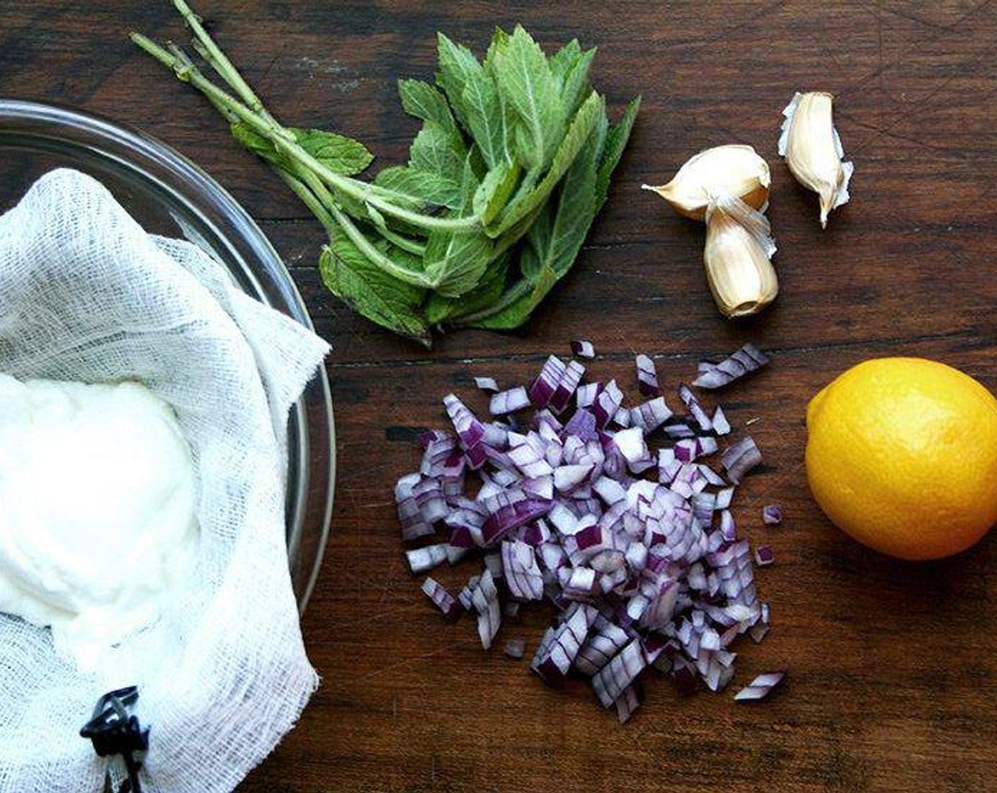 step 6 To make the tzatziki, stir together the Greek Yogurt (1 cup), Red Onions (2 Tbsp), Fresh Mint (2 Tbsp), and Garlic (1 clove). Season with a pinch of Kosher Salt (to taste) and a splash of juice from Lemon (1). Add more salt or lemon or anything else if necessary. Chill until ready to use.