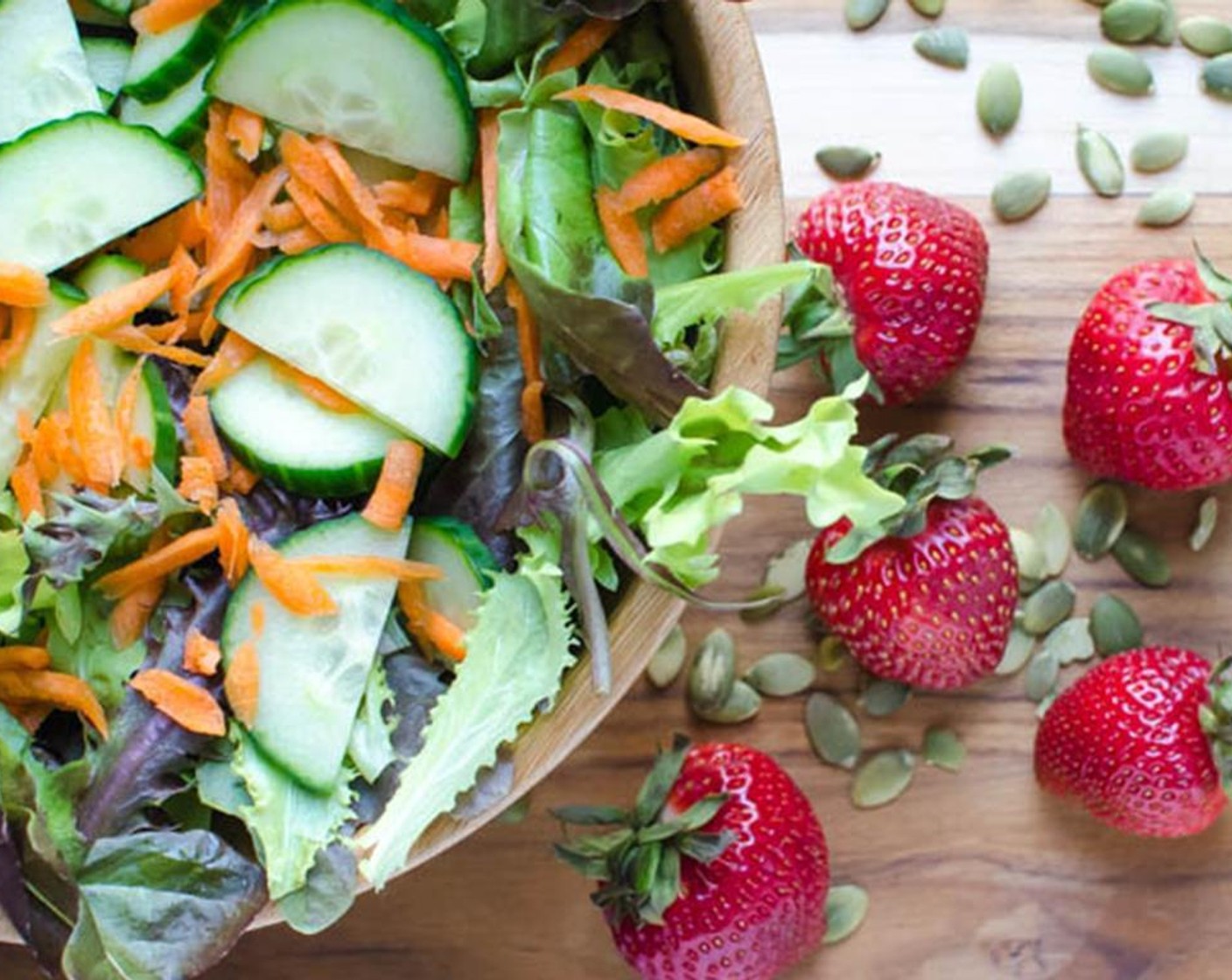 step 3 In a large bowl, combine the Salad Greens (6 cups), Carrot (1), Cucumber (3/4 cup), Fresh Strawberries (1 1/2 cups), Feta Cheese (1/2 cup), Pepitas (1/4 cup), Almonds (1/4 cup), and Pea Shoots (to taste), if using.