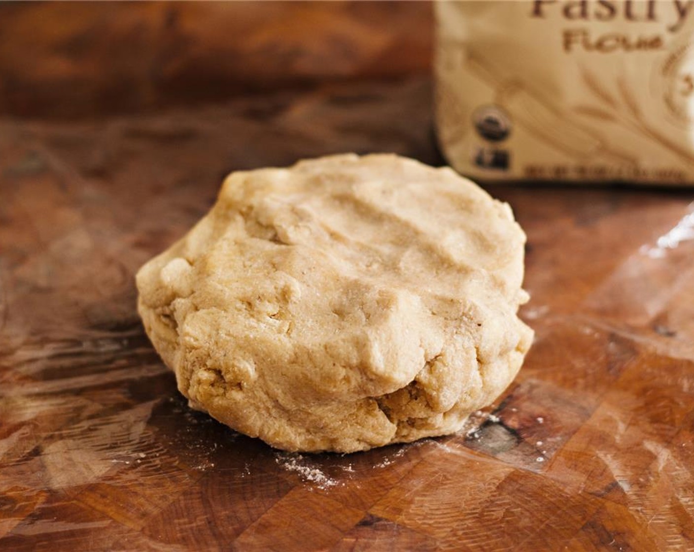 step 4 Scrape out the dough onto a sheet of plastic wrap. Use your hands to form it into a ball, then cover with another piece of plastic wrap.