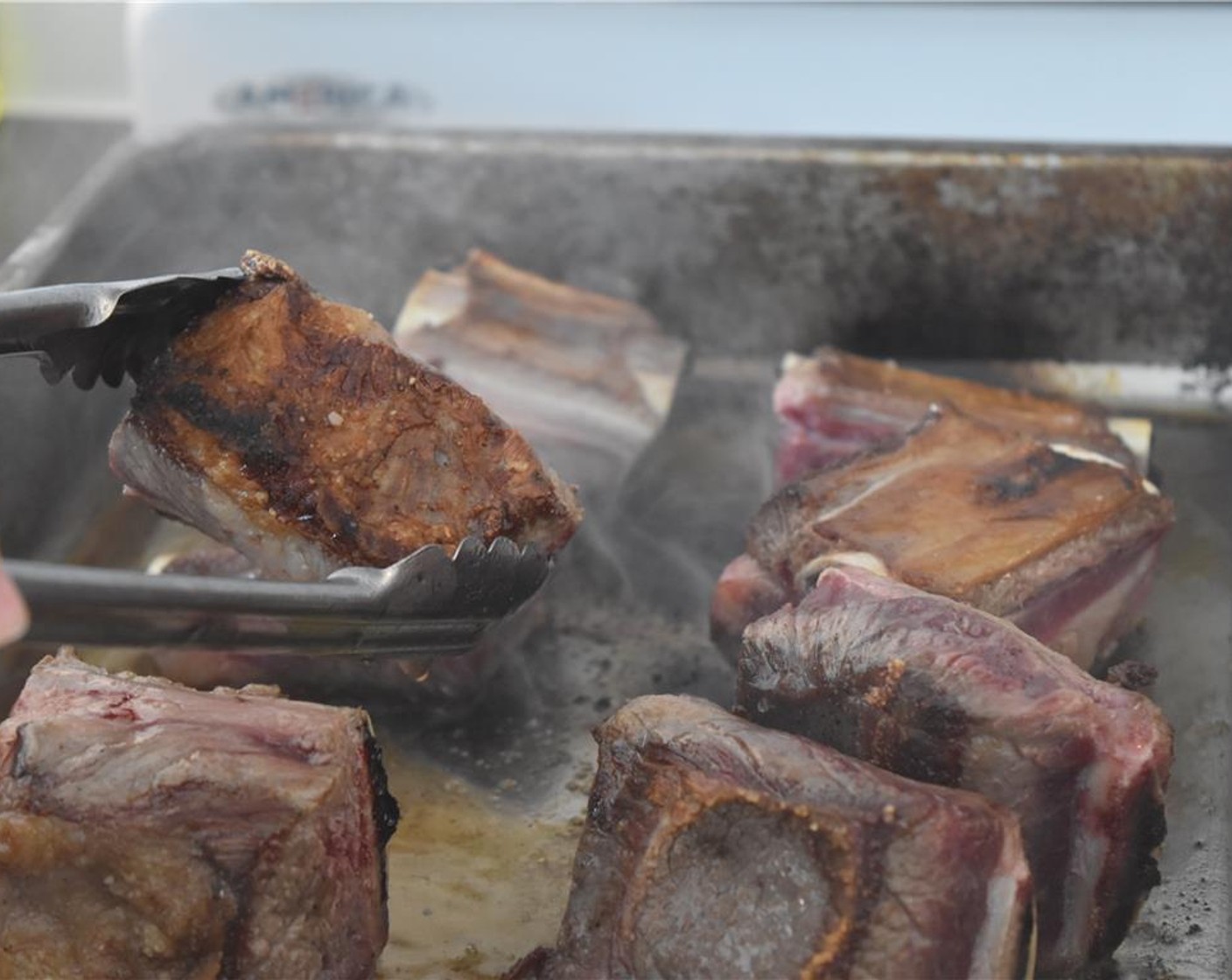 step 5 When the pan is hot and the oil is shimmering, place the ribs bone-side down in the pan. Allow them to sear without moving them for about 5 minutes, or until they're caramelized and brown.