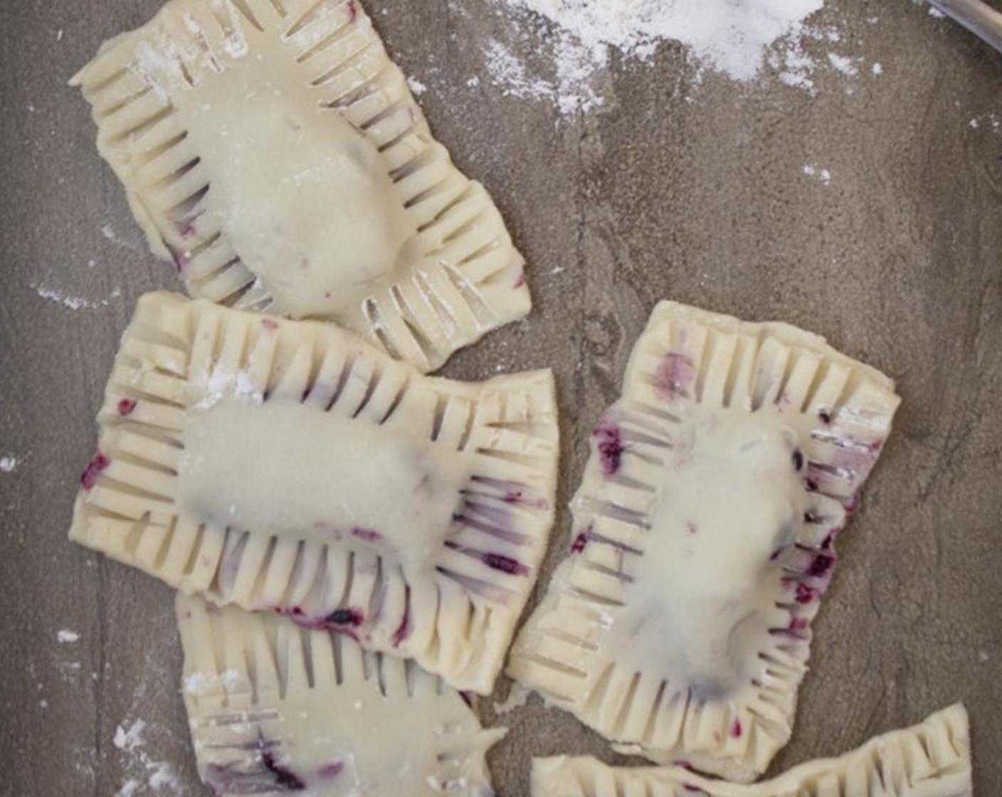step 6 Place another piece of pie dough on top.With your finger push down around the corners to make sure none of the blueberry pie filling with seep out. Next, dip a fork in some flour and imprint the edges of the pie pocket.