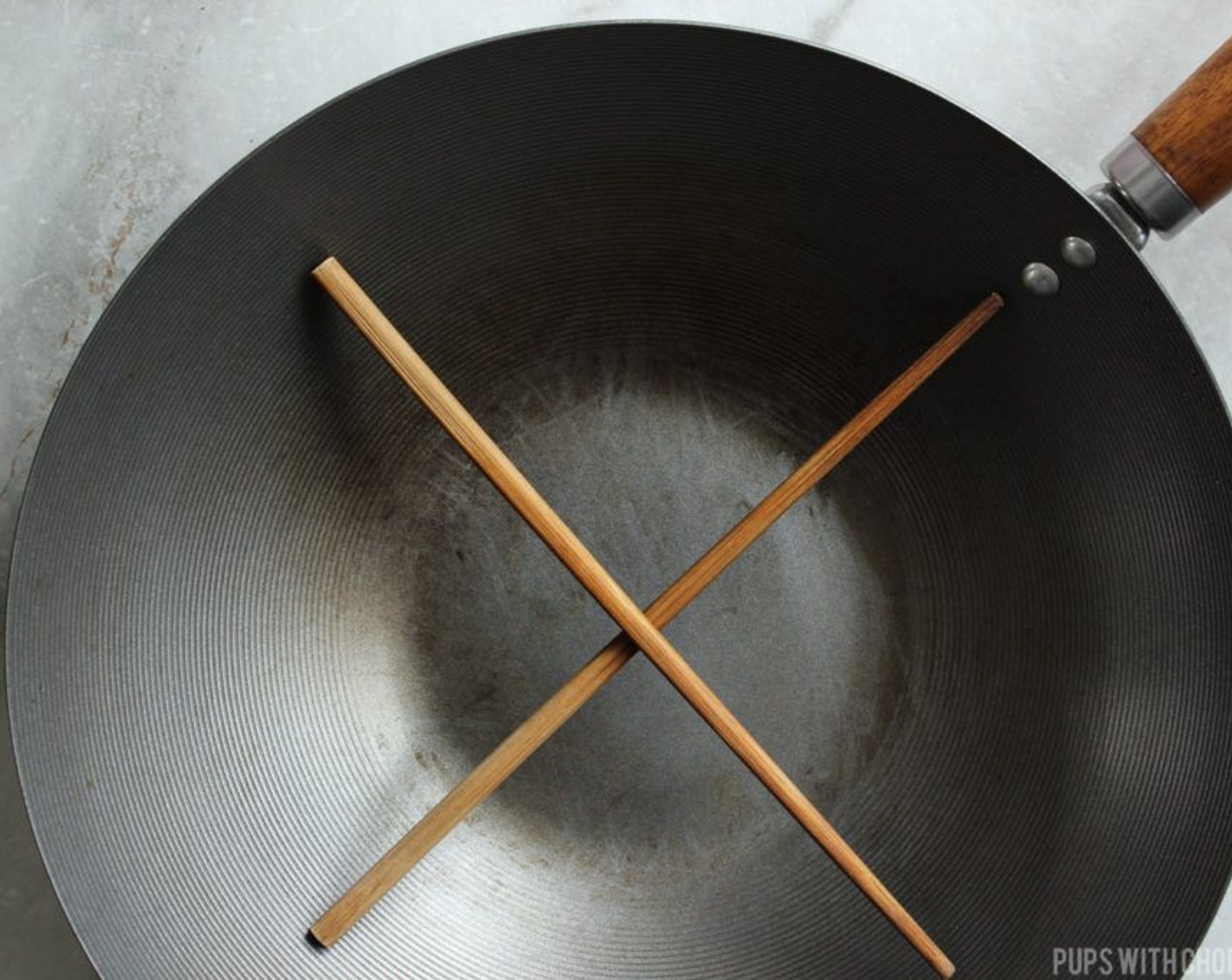 step 7 Using a wok or high walled pan set the bamboo steamer/metal doohickey/criss-crossed wooden chopsticks to the bottom of the pan or wok.