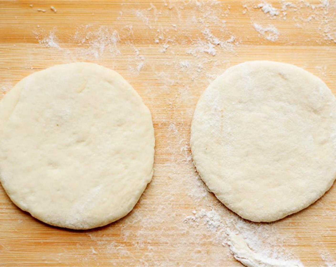 step 5 Punch the air out of the dough ball. On a slightly floured kitchen board, roll the dough into a long log around 5cm in diameter. Cut the long log into 12 equal portions. Take one portion out, press it slightly and then roll out to a around wrapper using a rolling pin.