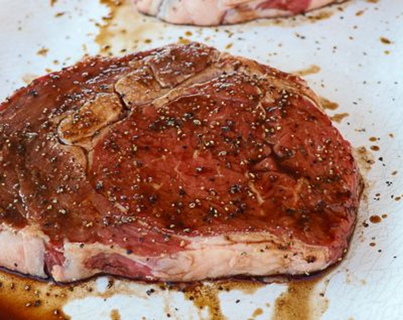 step 2 Tenderize Boneless Ribeye Steak (2), season with Kosher Salt (to taste) and Ground Black Pepper (to taste), drizzle with Balsamic Vinegar (1 Tbsp) and Worcestershire Sauce (2 Tbsp).