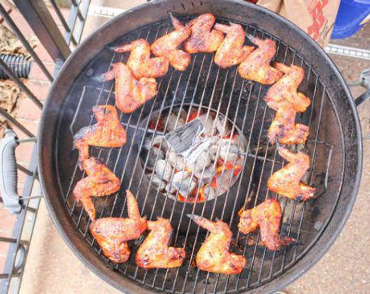 step 3 Place the wings on the cooking grate in the indirect zone towards the outside of the cooking grate and add 1 chunk of pecan wood directly on the grate over the vortex.