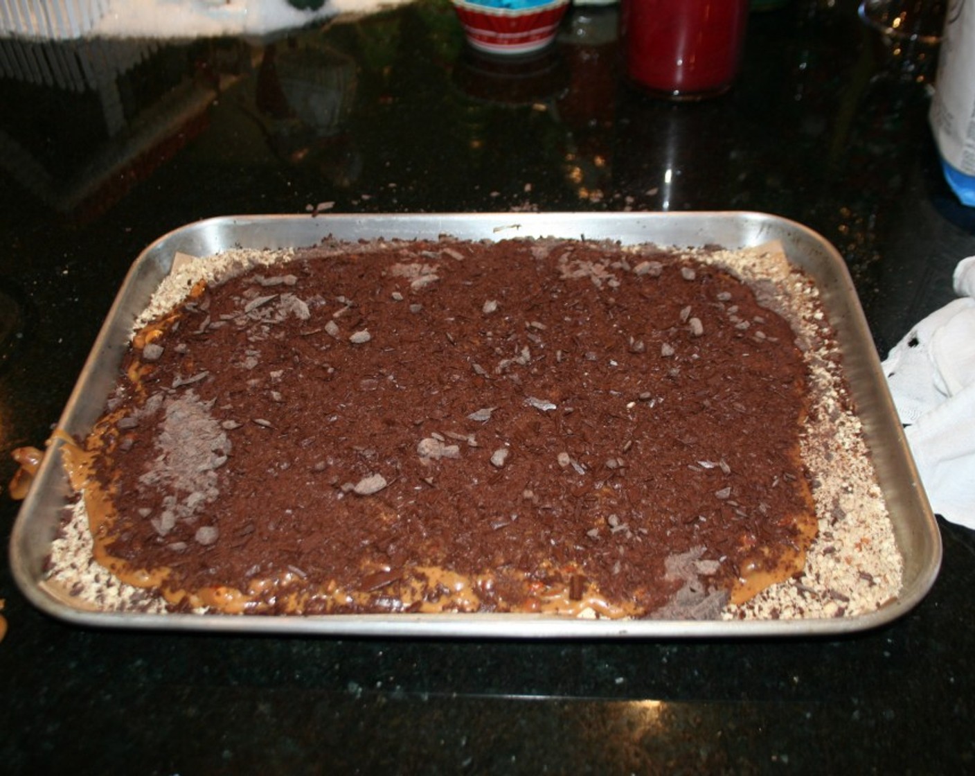 step 7 Then sprinkle with the Chocolate (2 cups) on top and spread with an offset spatula to smooth it out and sprinkle with a little more of the almond meal. I place it in the refrigerator for 30 minutes. Remove and break up into pieces.