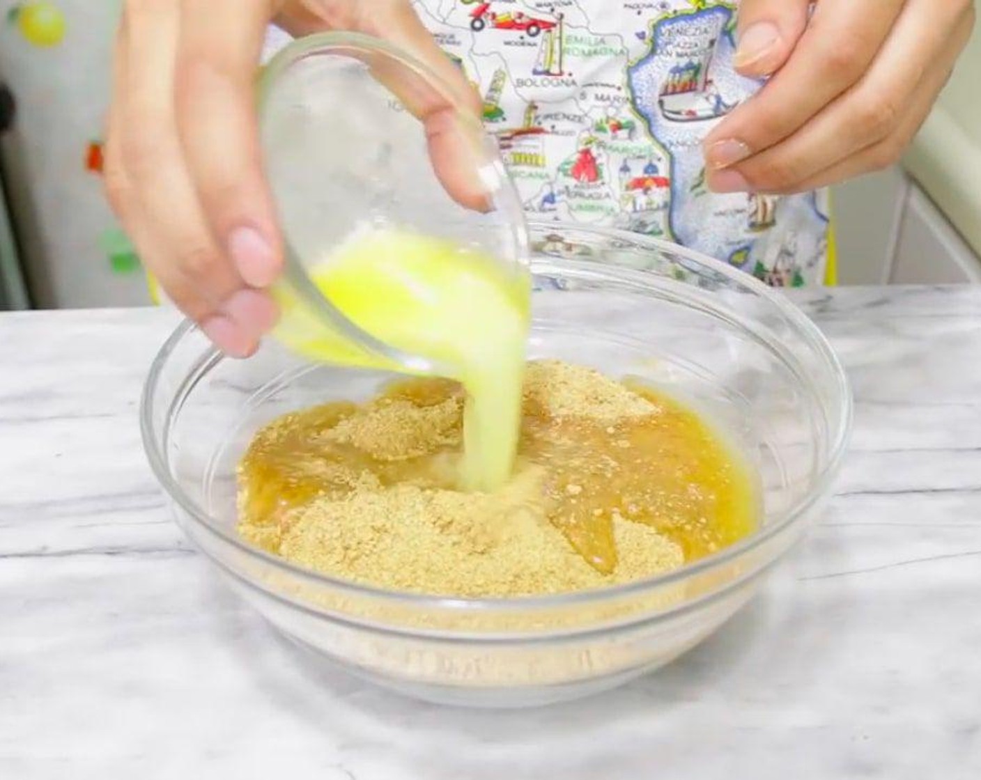 step 3 In a medium size bowl, mix together the Graham Cracker Crumbs (2 cups) and Butter (1/2 cup). Mix until it looks like wet sand.