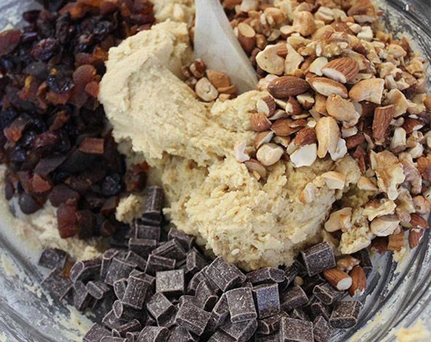 step 7 Add the Dried Cranberries (3/4 cup), Dried Apricot (1/2 cup), chopped nuts, and Semi-Sweet Chocolate Chips (1 cup) into the batter and mix with a wooden spoon to combine.