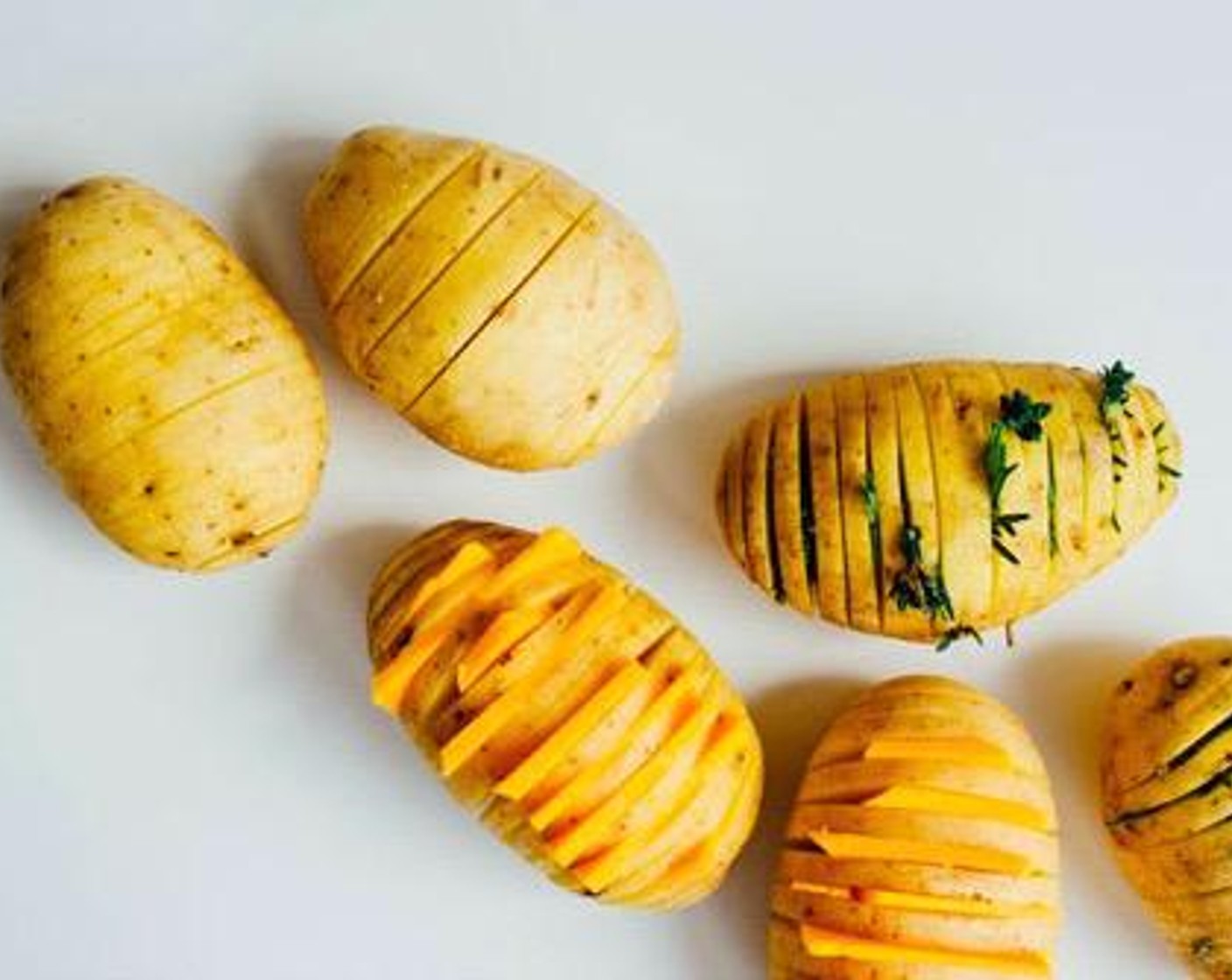 step 2 Stuff Sharp Cheddar Cheese (1 cup) between potato slices. Set in a parchment paper-lined slow cooker and brush with Olive Oil (1 tsp). Cook on high for 3 hours, or until potatoes are soft.