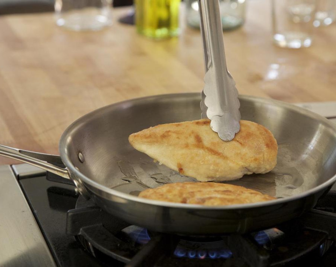 step 5 Heat Olive Oil (3 Tbsp) in a large sauté pan over medium-high heat. Place the chicken breasts in the pan and brown for 3 minutes on one side.