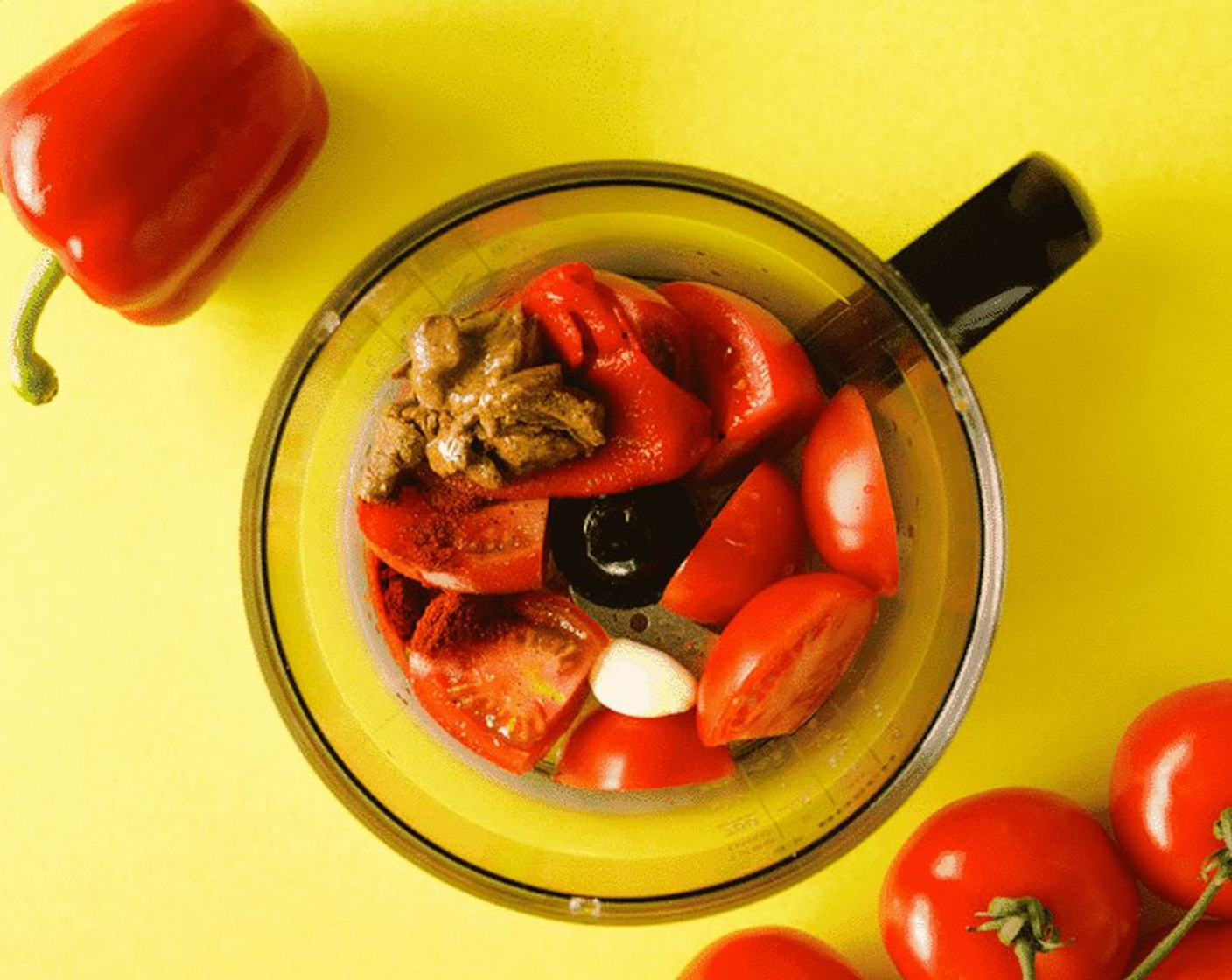 step 1 Add Red Chili Pepper (1), Roma Tomato (1 cup), Olive Oil (1/4 cup), Almond Butter (3 Tbsp), Garlic (1 clove), the juice from Lemon (1), Smoked Paprika (1/2 tsp), Salt (1/2 tsp), and Ground Black Pepper (1/4 tsp) to a food processor.