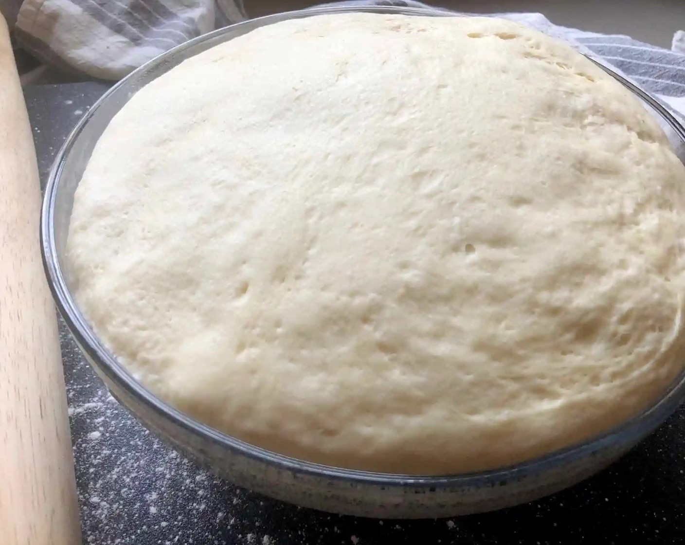 step 5 When the dough has doubled in size, turn it out onto a lightly floured work surface, punch it down, and roll it into a ball using your hands. Roll the dough into a rectangle measuring about 12x18-inches.