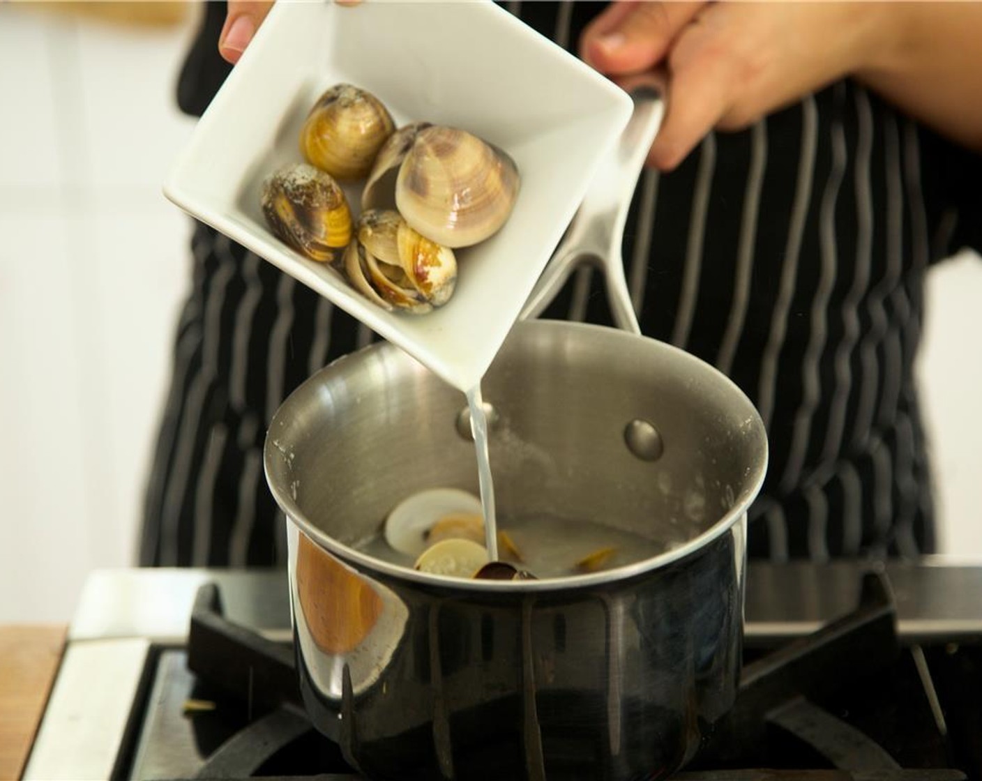 step 3 Carefully add Whole Cooked Clams (1 lb) being sure not to break the shells, and simmer until clams open and are just heated through, about 2 minutes.