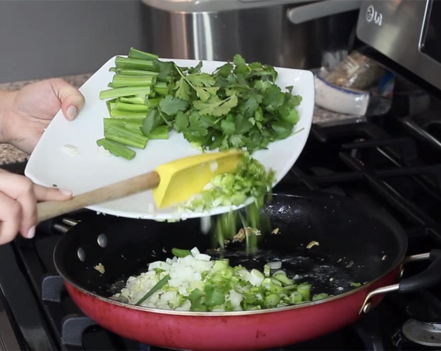 step 13 Add a little more oil to the pan, and cook the onion, garlic, and sliced scallions whites, stirring constantly, until fragrant, about 1 minute.