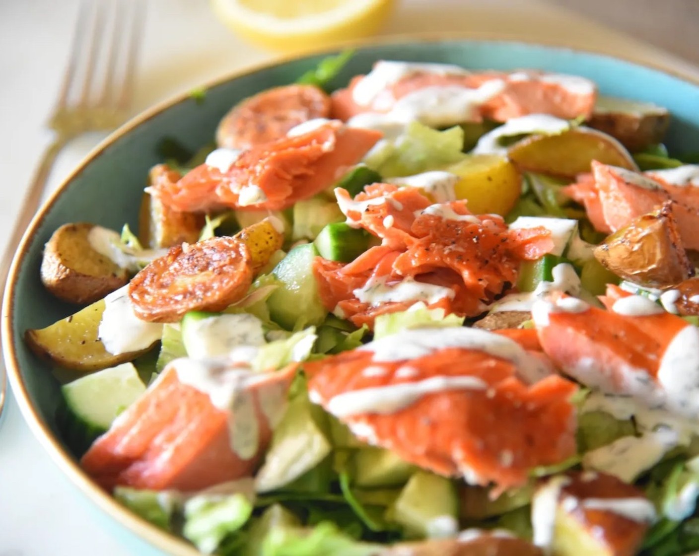 step 9 Using a fork, break the salmon up and divide it among the four plates as well. Drizzle the dressing over each salad. Serve warm, or at room temperature.