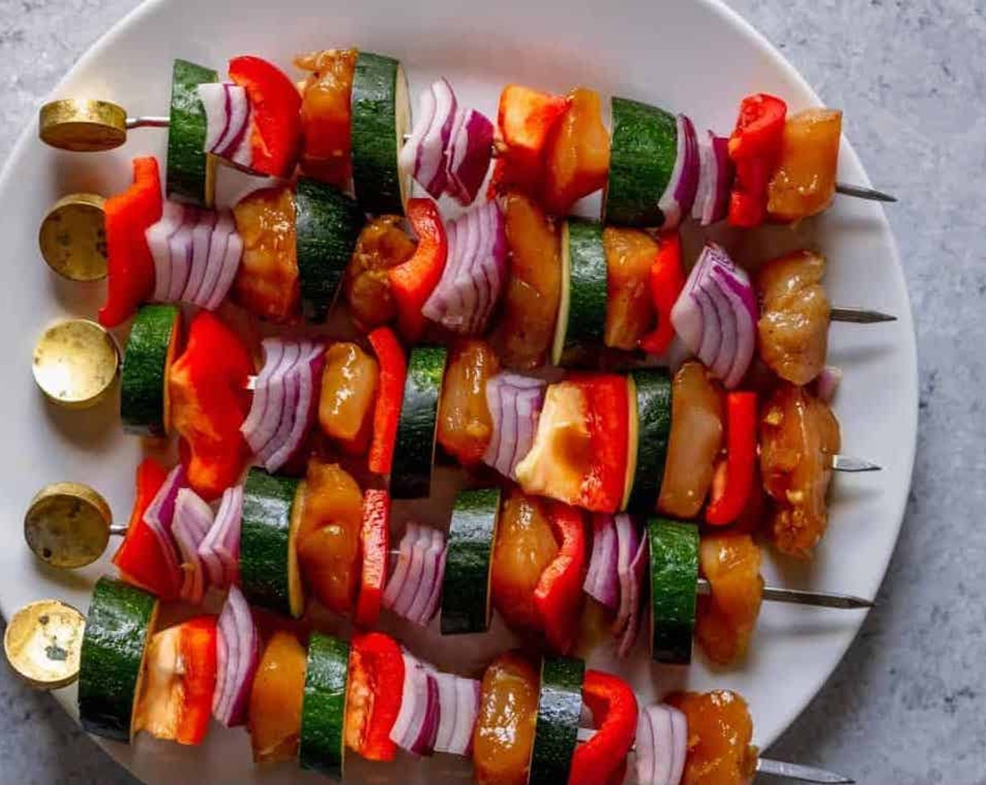 step 4 Preheat the grill to medium heat. Thread the chicken, Red Bell Pepper (1), Red Onion (1), and  Zucchini (1) onto the skewers. Place skewers onto the grill and cook for 5-7 minutes per side, until cooked through.
