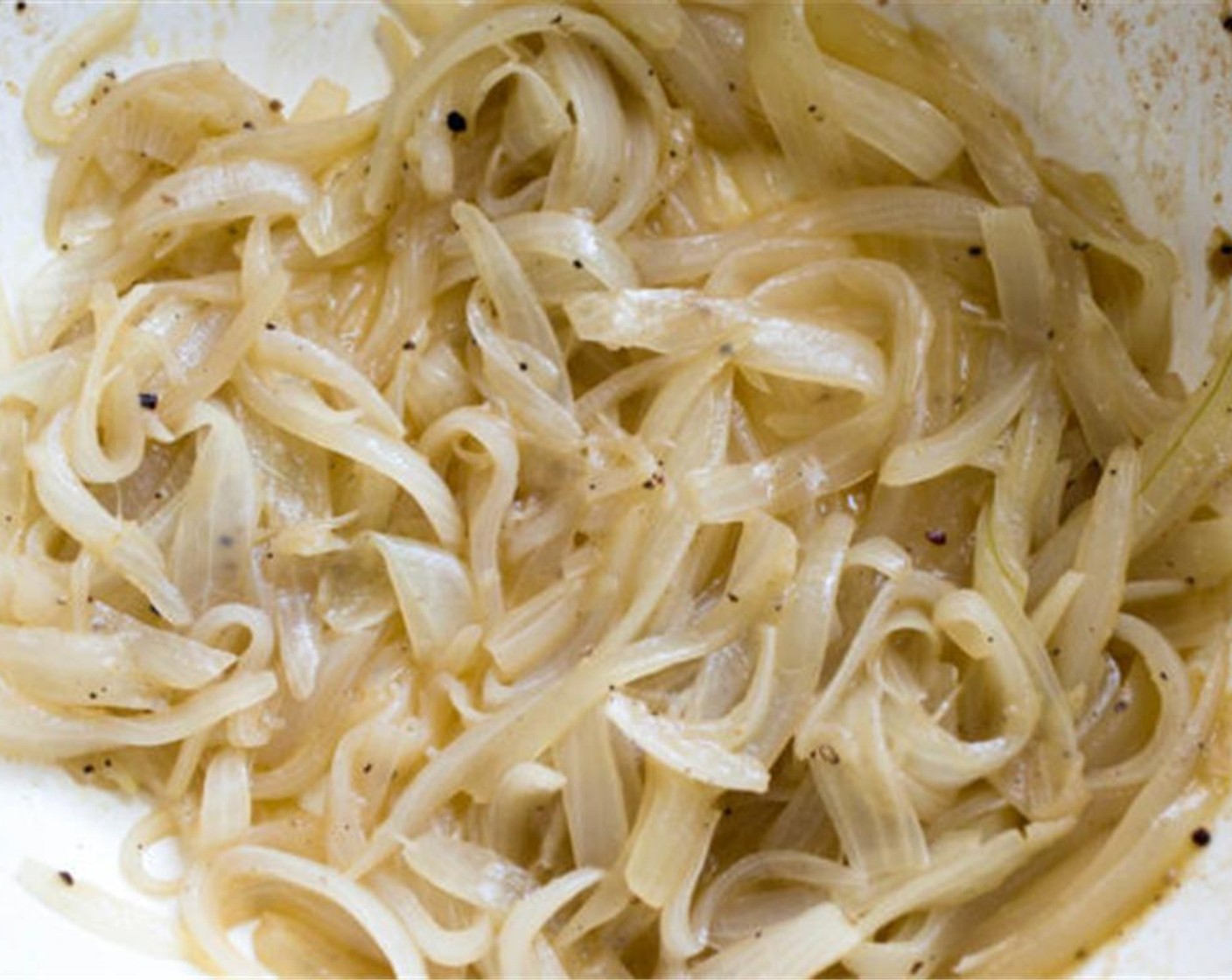 step 2 Place the onions in a large non-stick skillet over medium heat with 1 tablespoon of Extra-Virgin Olive Oil (1/4 cup), McCormick® Garlic Powder (1/2 tsp), Ground Black Pepper (to taste) and 2 tablespoon water. Evenly coat the onions and stir occasionally to prevent burning.