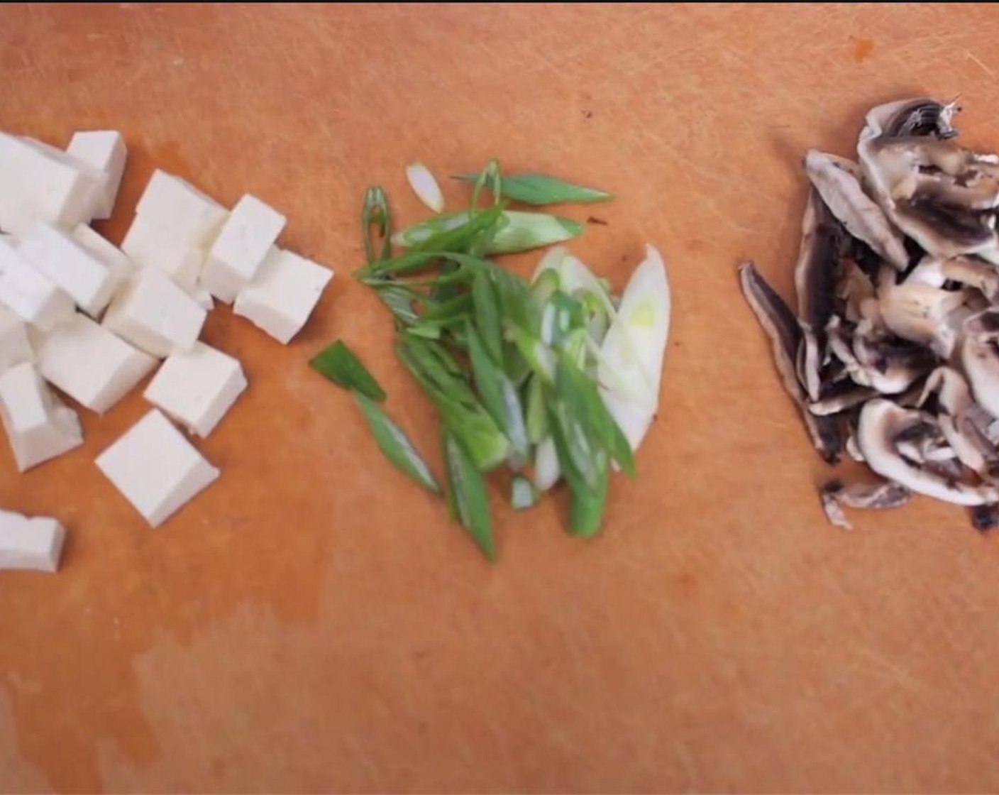 step 2 Meanwhile, cube the Tofu (1/4 cup). Slice the Button Mushroom (1) and chop the Scallion (1 stalk) on a diagonal.