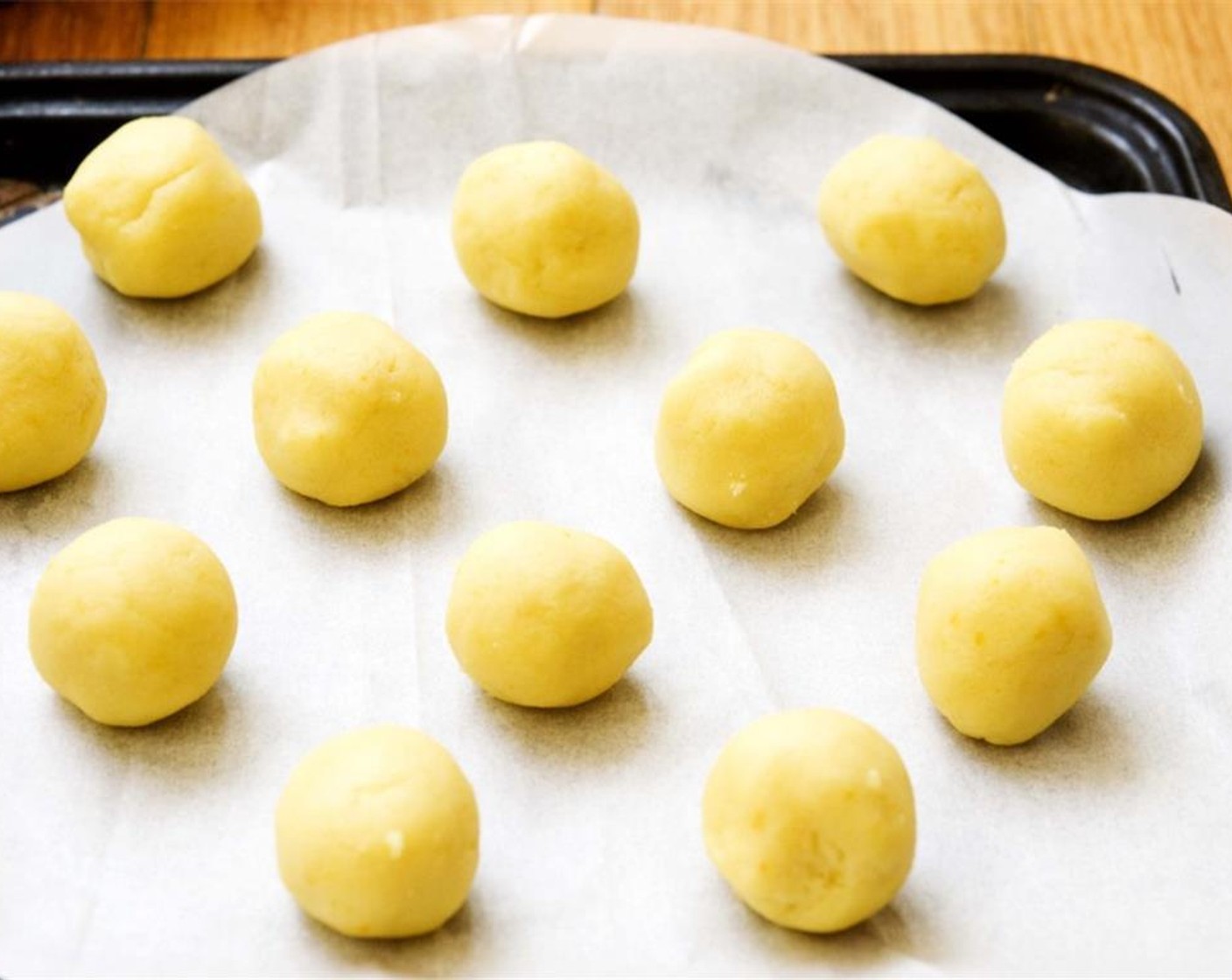 step 6 Scoop out a tablespoon of dough, then roll them into balls between your hands. Place them on parchment paper. Bake for 13 minutes in your preheated oven.