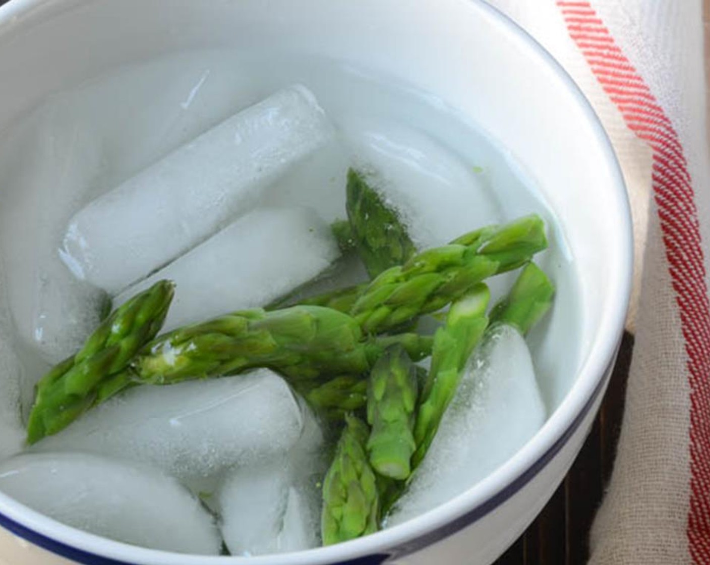 step 7 Add the asparagus tips to the boiling water and cook for 1-2 minutes until just tender. Use a slotted spoon or spider to transfer the asparagus tips from the boiling water to the ice bath to shock them and stop the cooking. Set aside until ready to serve.