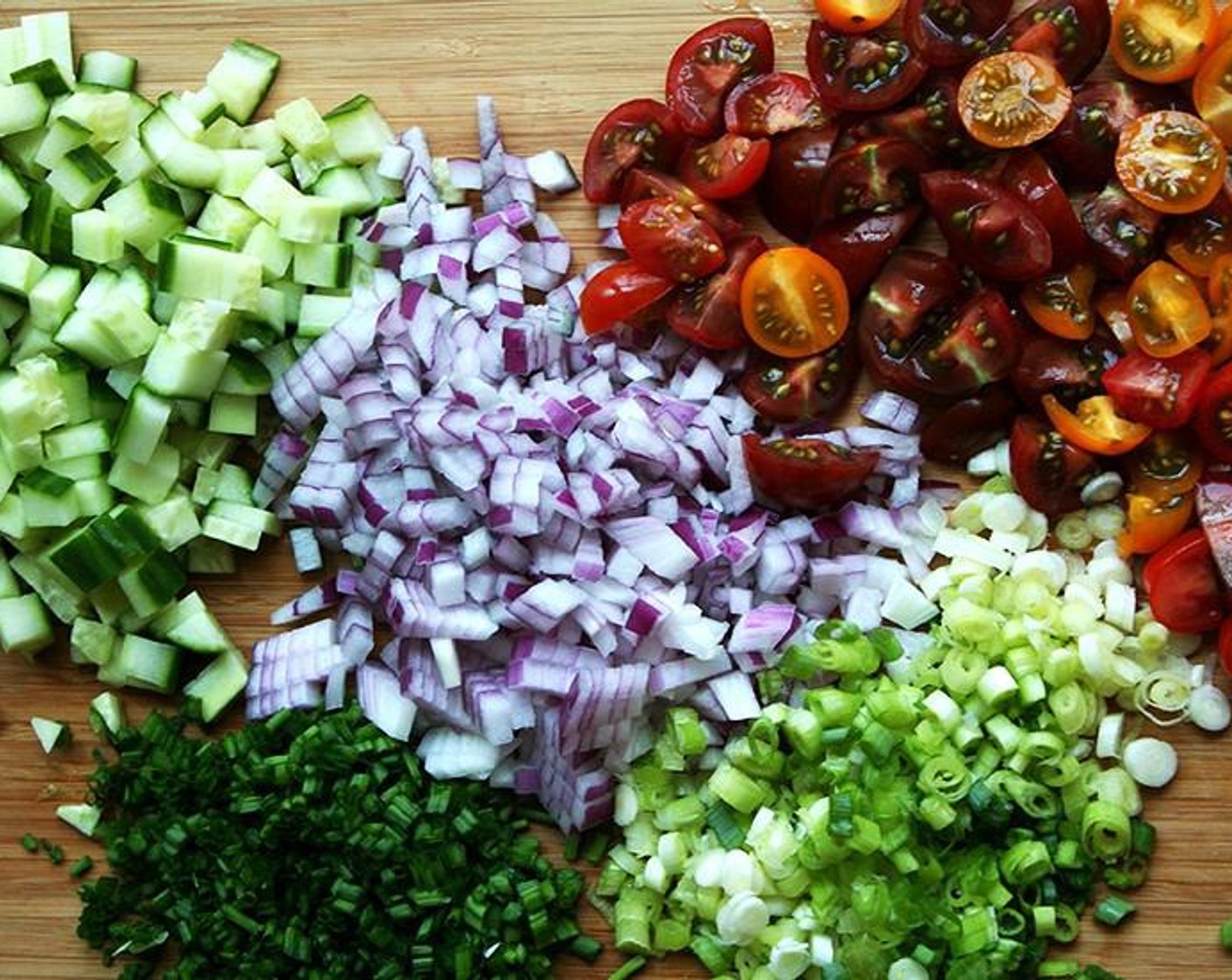 step 2 Meanwhile, finely dice the Red Onion (1). Mince the white and light green portion of the Scallion (1 bunch). Mince the Fresh Chives (1 bunch). Small dice the English Cucumber (1). Halve or quarter the Cherry Tomato (1 cup) depending on their size. Mince the Fresh Parsley (1 bunch). Mince the Fresh Mint (4 Tbsp).